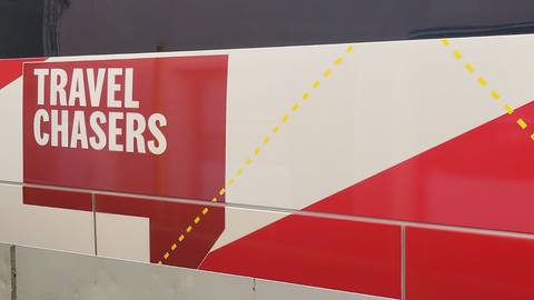 Close-up of a red and white Travel Chasers graphic on the side of a vehicle