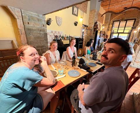 Friends enjoying food and wine around a rustic Italian restaurant table