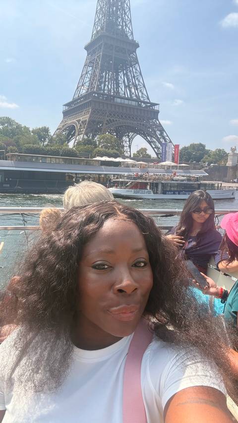 Selfie on a river cruise boat with other passengers and a passing vessel on the Seine.