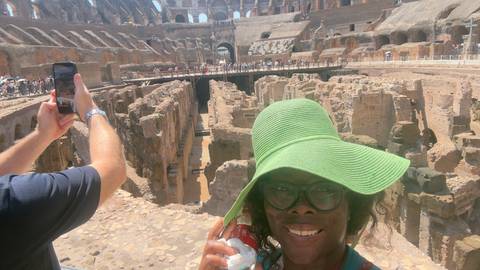 Traveler in a green sunhat takes a selfie inside the ancient ruins of the Colosseum.
