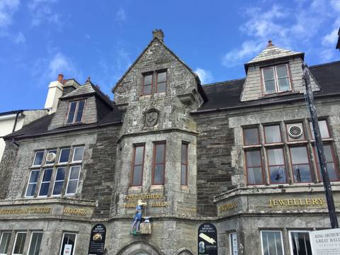 Historic grey-stone building signed King Arthur's Great Halls under a blue sky