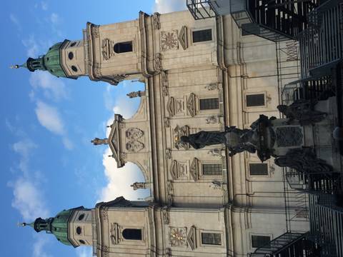 Facade of Salzburg Cathedral with statues and evening blue sky behind