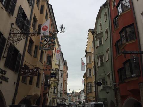 Narrow pedestrian street in Innsbruck Old Town with colourful facades and wrought-iron signs