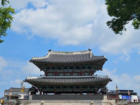 Close-up of a traditional Korean temple roof set against a bright blue sky.