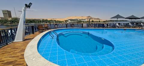 Sparkling blue swimming pool on the deck of a Nile cruise ship with desert backdrop.