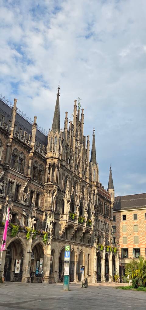 Ornate neo-gothic spires and statues of Munich’s New Town Hall rise against a pale morning sky.