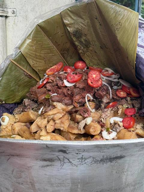 Traditional Nicaraguan feast of meat and yucca wrapped in banana leaves, topped with tomatoes.
