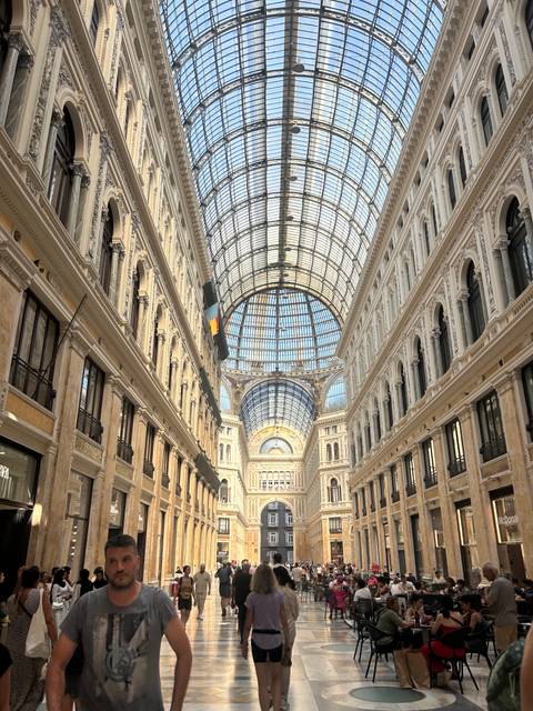 Elegant glass-roofed arcade with ornate architecture and long perspective in Naples.
