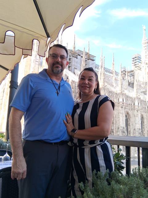 Couple posing in front of Milan Duomo’s elaborate marble exterior