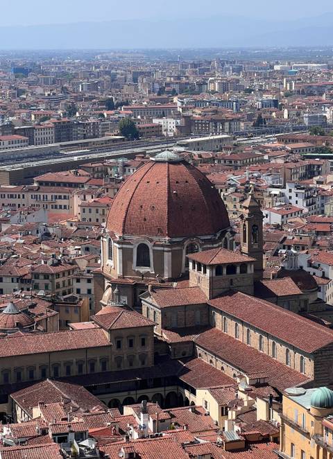High vantage view of red-tiled dome rising above clustered Florence rooftops
