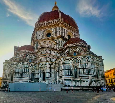 Florence Cathedral illuminated by warm evening light against clear sky