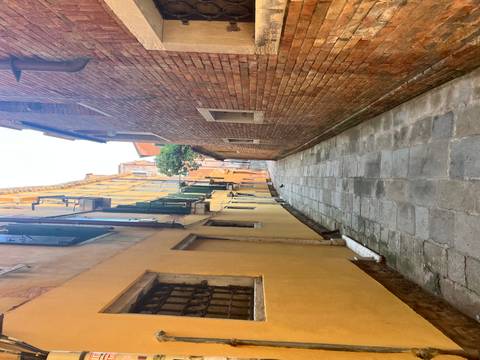 Narrow empty alleyway between aged brick and pastel buildings in Venice
