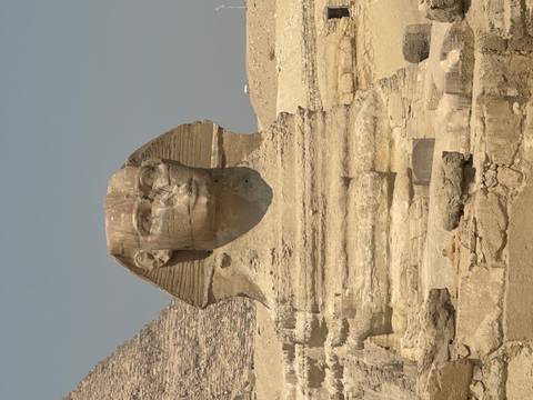 Close portrait view of the Great Sphinx statue against a hazy sky.