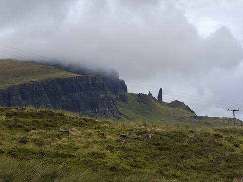 Moody view of the Old Man of Storr rock pinnacle emerging from misty cliffs