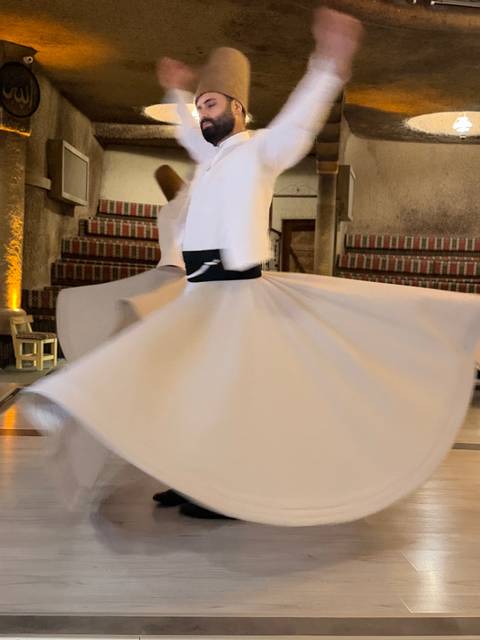 Blurred motion of a whirling dervish performing the traditional Sufi dance indoors