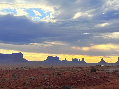 Silhouettes of Monument Valley buttes under a colorful evening sky