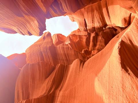 Narrow orange sandstone walls of Antelope Canyon glowing in reflected light