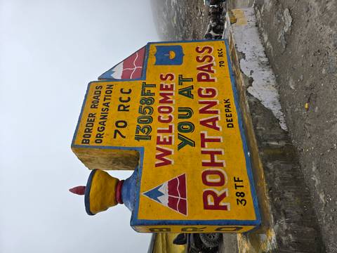 Colorful roadside stone sign welcoming visitors to Rohtang Pass at 13,058 ft.