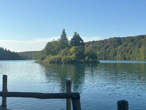 Serene lake surrounded by dense forested hills in Plitvice Lakes National Park.