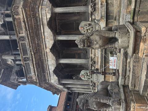 Stone lions guard the entrance of an ancient temple building with a sign requesting visitors not to enter.