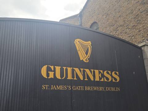 Close-up of the black timber gate bearing the gold Guinness harp logo at St. James’s Gate Brewery.