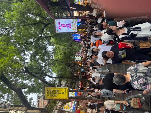 Crowded Muslim Street night market in Xi'an with neon signs and food vendors.