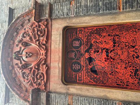 Decorative red carved window panel with traditional Chinese phoenix and dragon motifs.