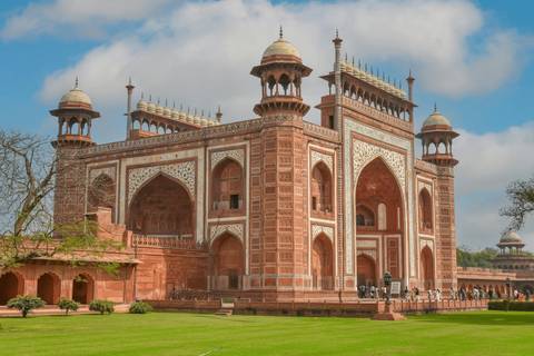 Grand Mughal gateway with intricate red sandstone and marble inlays in the Taj Mahal complex.
