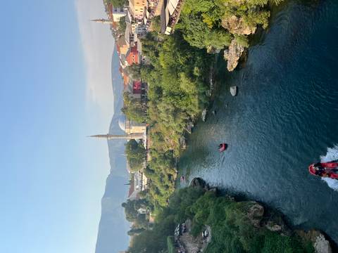 River running past a mosque and town with speedboats creating wakes in the clear water