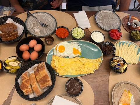 Top-down view of a generous Balkan breakfast spread with eggs, bread, cheeses and spreads