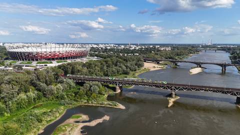 aerial view of Warsaw National Stadium beside the Vistula River and multiple bridges