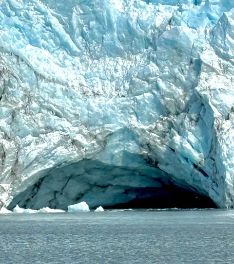 close-up texture of blue glacial ice with crevasses and crystalline patterns
