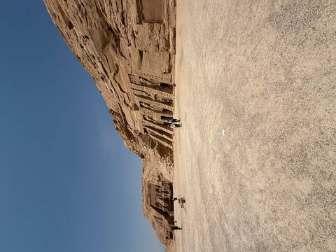 Grand temples of Abu Simbel carved into sandstone cliffs with a vast forecourt and a few tourists