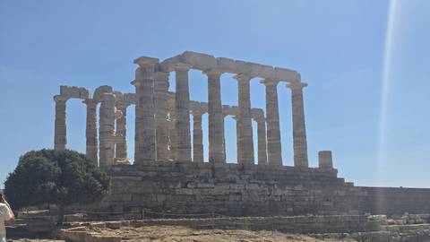Side view of the Temple of Poseidon with bright sunlight casting shadows on the marble columns.