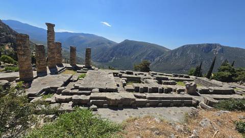 Stone foundations and standing columns of the Temple of Apollo overlook a mountain valley at Delphi.