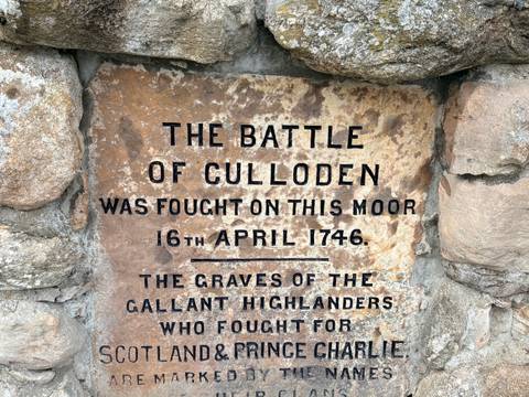 Stone plaque commemorating the Battle of Culloden with bold black lettering on weathered rock