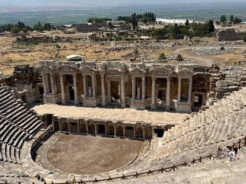 Well-preserved Roman theatre of Hierapolis viewed from above, surrounded by ruins.
