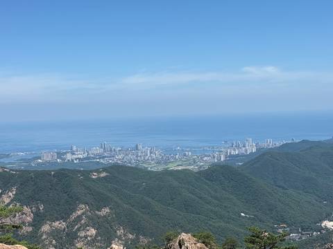 View from mountain over coastal city skyline beside vast blue sea