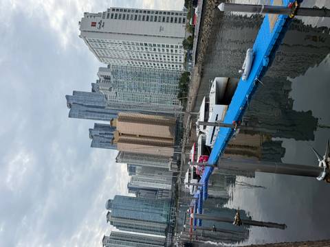 Marina with catamarans moored against backdrop of tall modern apartment towers