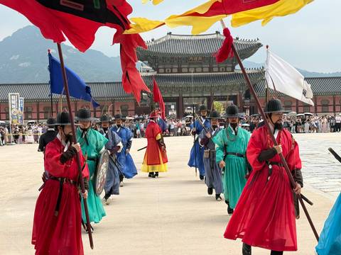 Traditional royal guard changing ceremony with brightly colored robes at palace gate