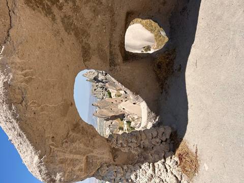 Fairy-chimney rock spires of Cappadocia framed through a natural tufa arch.