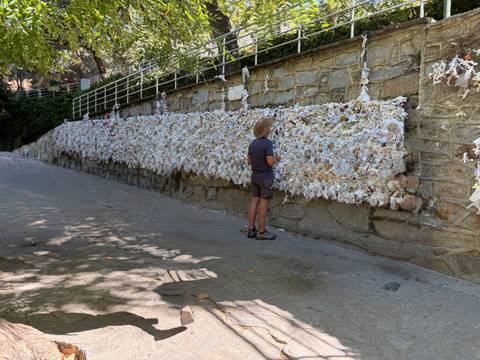 Traveler reading thousands of paper wishes attached to the wishing wall at the House of Virgin Mary.
