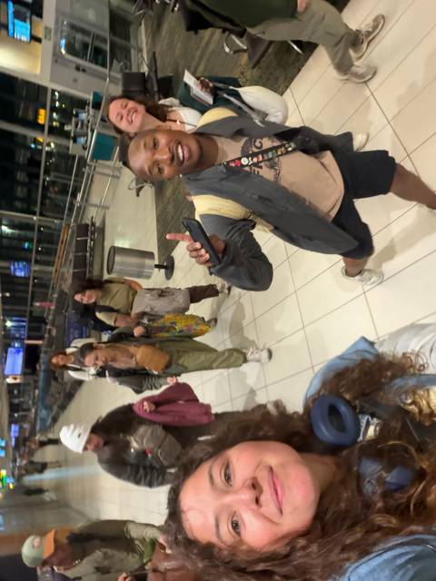 Blurry selfie while rushing through an airport concourse with backpacks.