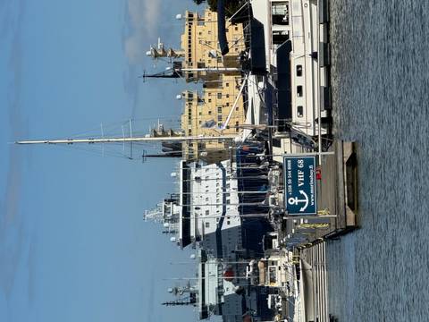 Harbor view with yachts, icebreakers and Finnish signage under bright blue sky.