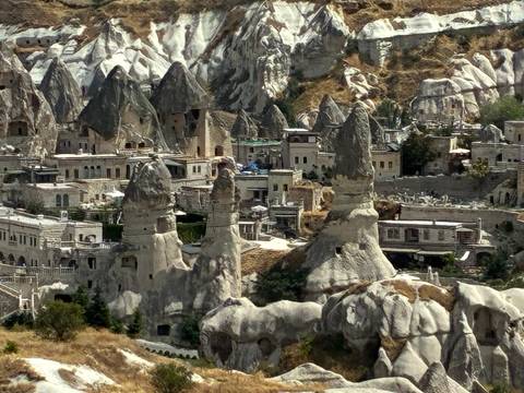 Panoramic view of Goreme’s cave houses and pointed rock spires clustered in a rugged valley.