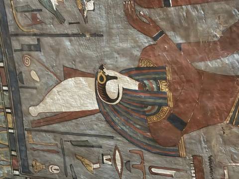 Vertical fresco of the falcon-headed god Horus wearing the double crown on a tomb wall.