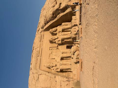 Sun-bathed colossal statues of Ramses II carved into the façade of Abu Simbel temple.