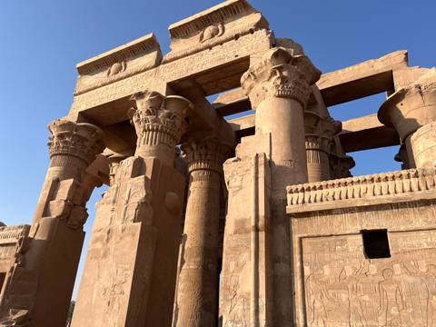 Close-up of towering stone columns with intricate hieroglyphs at Kom Ombo Temple.