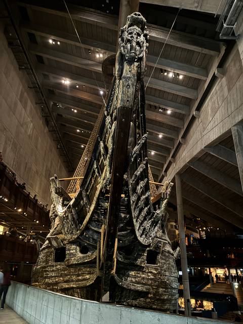 The massive wooden bow of the 17th-century Vasa warship displayed inside a dim museum hall.