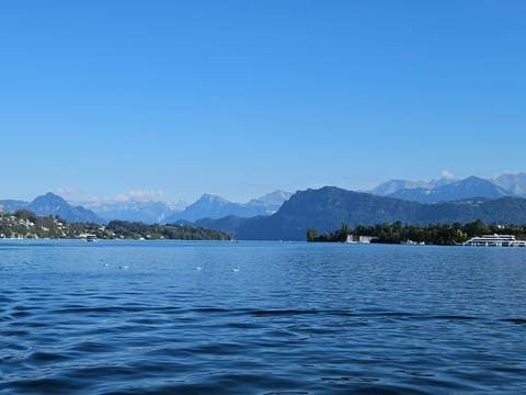 Expansive blue waters of Lake Lucerne framed by forested shores and distant alpine ridges